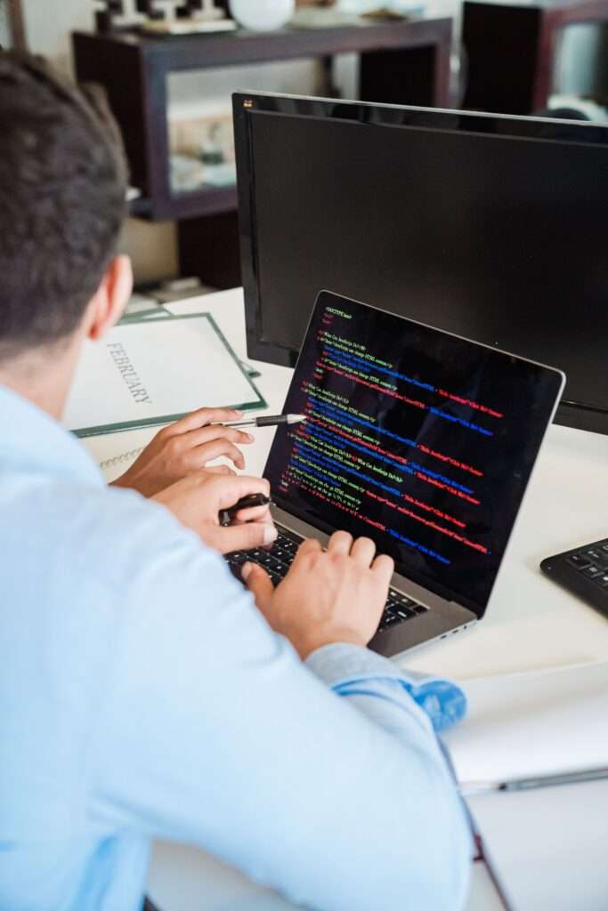 Consultor señalando pantalla con datos para desarrollo de software personalizado para empresas.